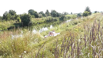 A casual passerby young guy saw a naked Milf sunbathing on river bank. Peeping. Spy camera. Naked in public. Nude beach. Wild beach