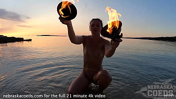 nude fire dancing on the beach at sunset
