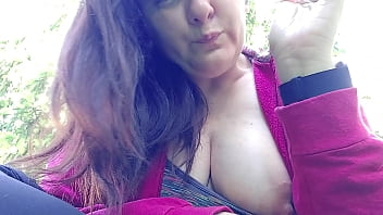 Nicoletta smokes in a public garden and shows you her big tits by pulling them out of her shirt