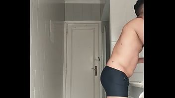 Sexy guy in black beach shorts shaving