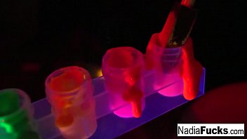 Black-light babes Nadia White and Ophelia suck off a colorful cock