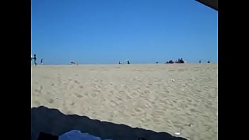 Busty blonde cutie in micro bikini flashing on the beach