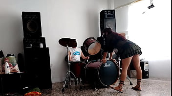 They play the drums for her - she dances, stripping and showing her ass