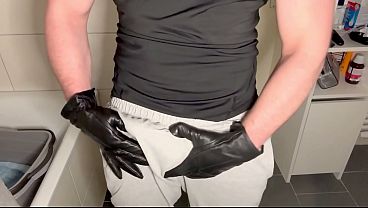 Deutscher Muskul&ouml_ser Meister in Lederhandschuhen und grauer Jogginghose