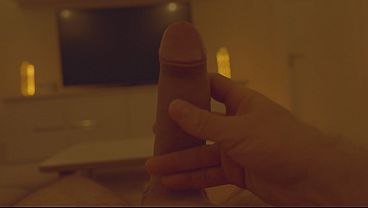 Massage of a large penis in front of a large TV